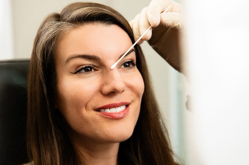 woman with a q-tip on her nose